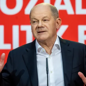 Ein Mann mit Halbglatze (Olaf Scholz) am Rednerpult