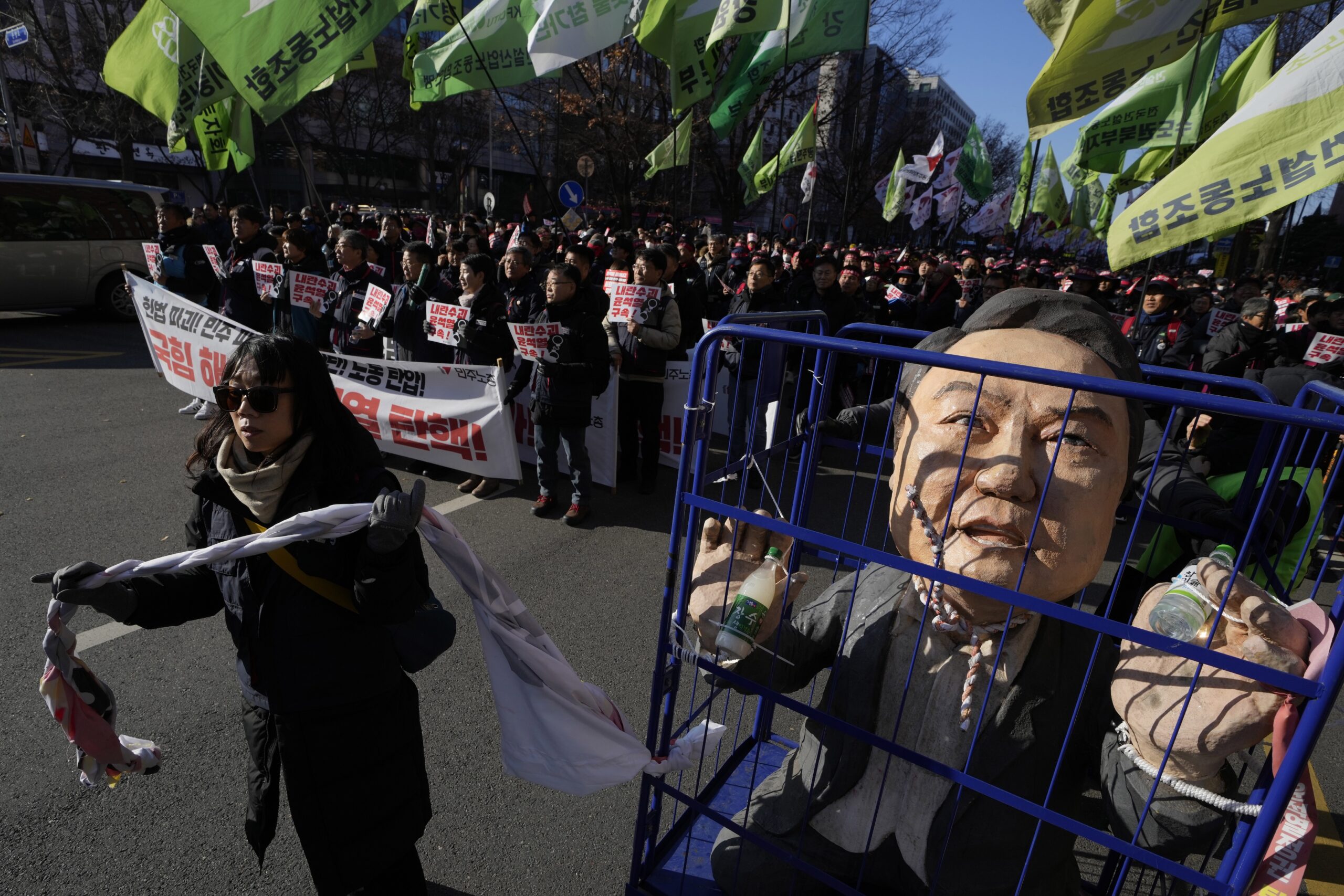 Eine Frau zieht eine Karikatur, die den inhaftierten südkoreanischen Präsidenten zeigt, während Demonstranten in der Nähe der Nationalversammlung seine Amtsenthebung fordern, nachdem das Kriegsrecht verhängt wurde.