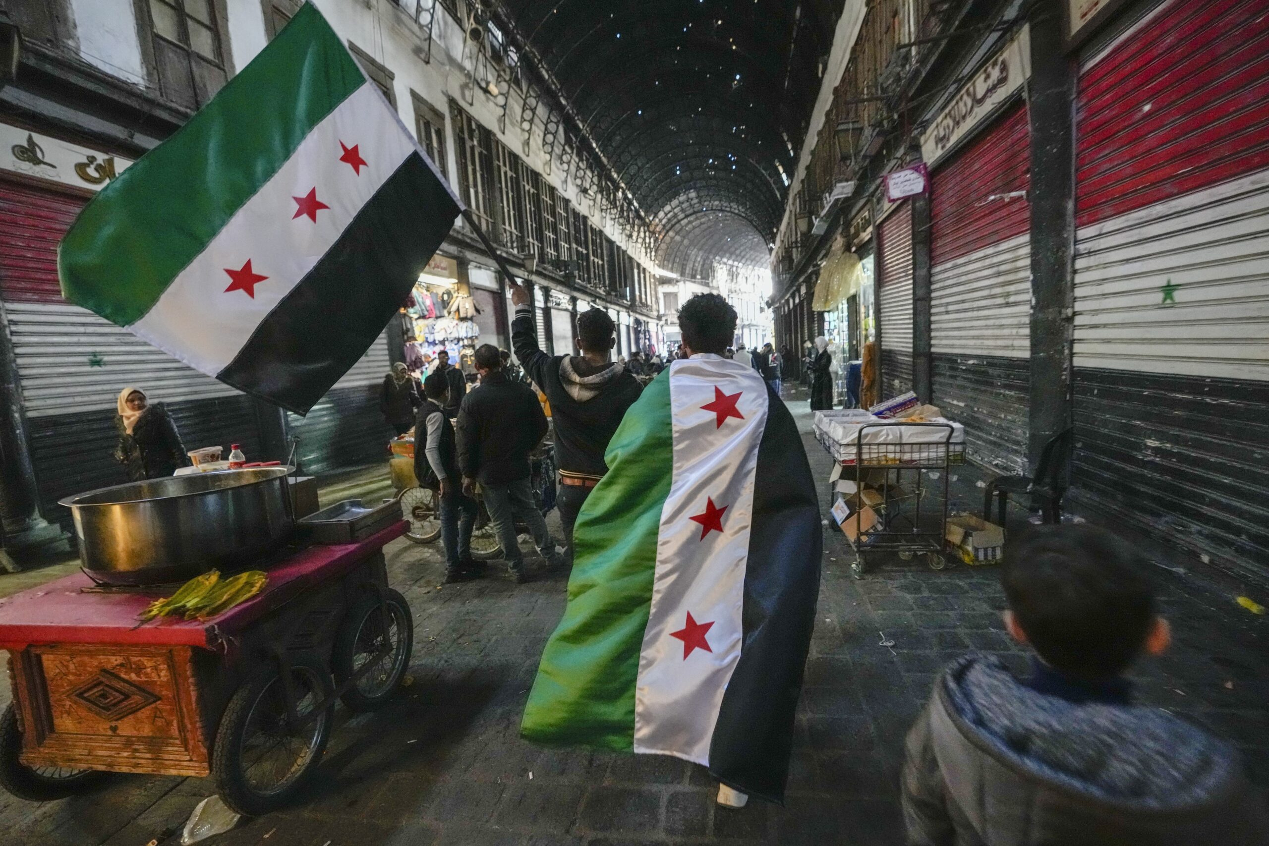 Nach dem Sturz des Assad-Regimes tragen junge Syrer die Flagge der Opposition durch Damaskus.