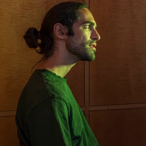 Ein Mann sitzt in dem Beichtstuhl vor der Kunstinstallation mit einem KI-Jesus.