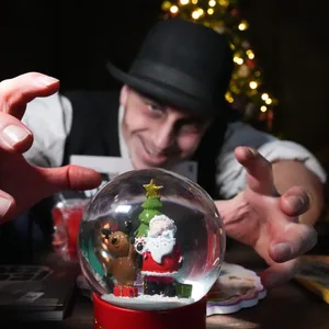 Schauspieler Marcel Casper als Friedrich greift während der Geschenke-Tauschaktion im Hamburg Dungeon nach einer weihnachtlichen Schneekugel.