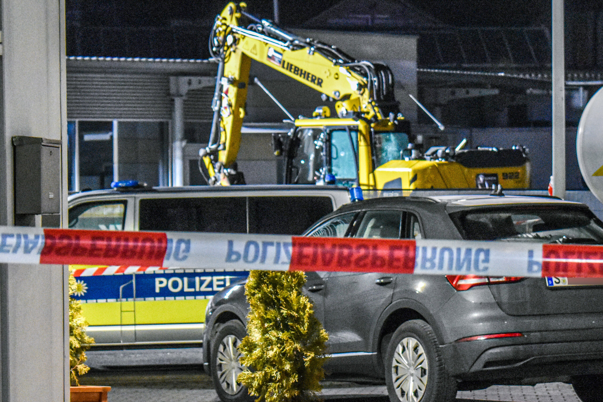 Ein Bagger steht nach einer mutmaßlichen Amokfahrt neben einem Autohaus in Tauberbischofsheim.