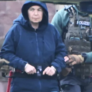 Polizisten führen die frühere RAF-Terroristin Daniela Klette zu einem Hubschrauber (Archivbild).