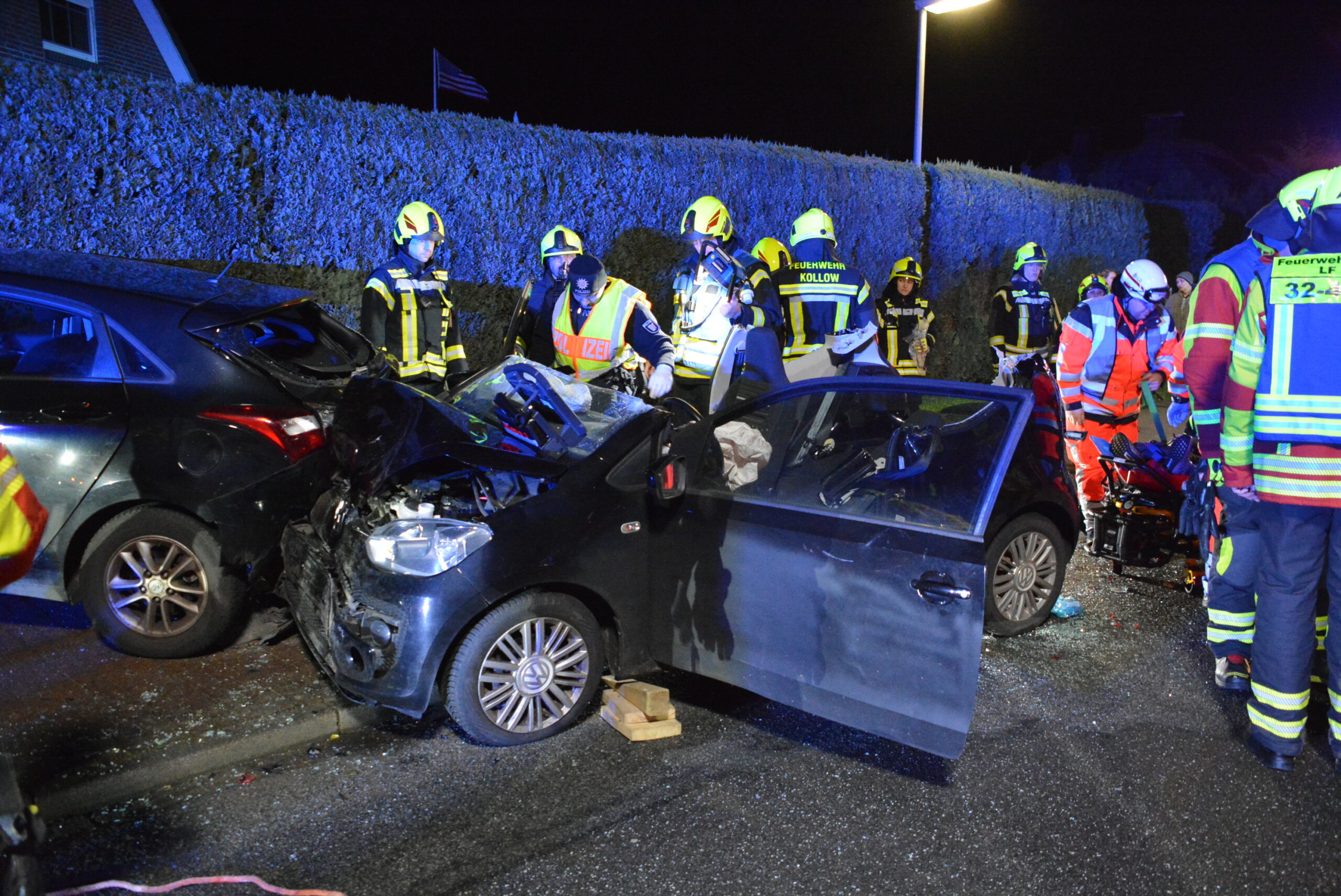 Ein beschädigter Wagen mit Rettungskräften am Straßenrand