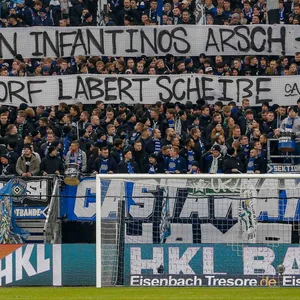 HSV-Fans halten ein Banner hoch, auf dem DFB-Boss Bernd Neuendorf kritisiert wird.