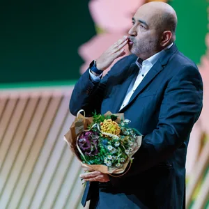 Omid Nouripour gibt nach seiner Abschiedsrede beim Grünen-Bundesparteitag einen Handkuss mit Blumenstrauß in der Hand.