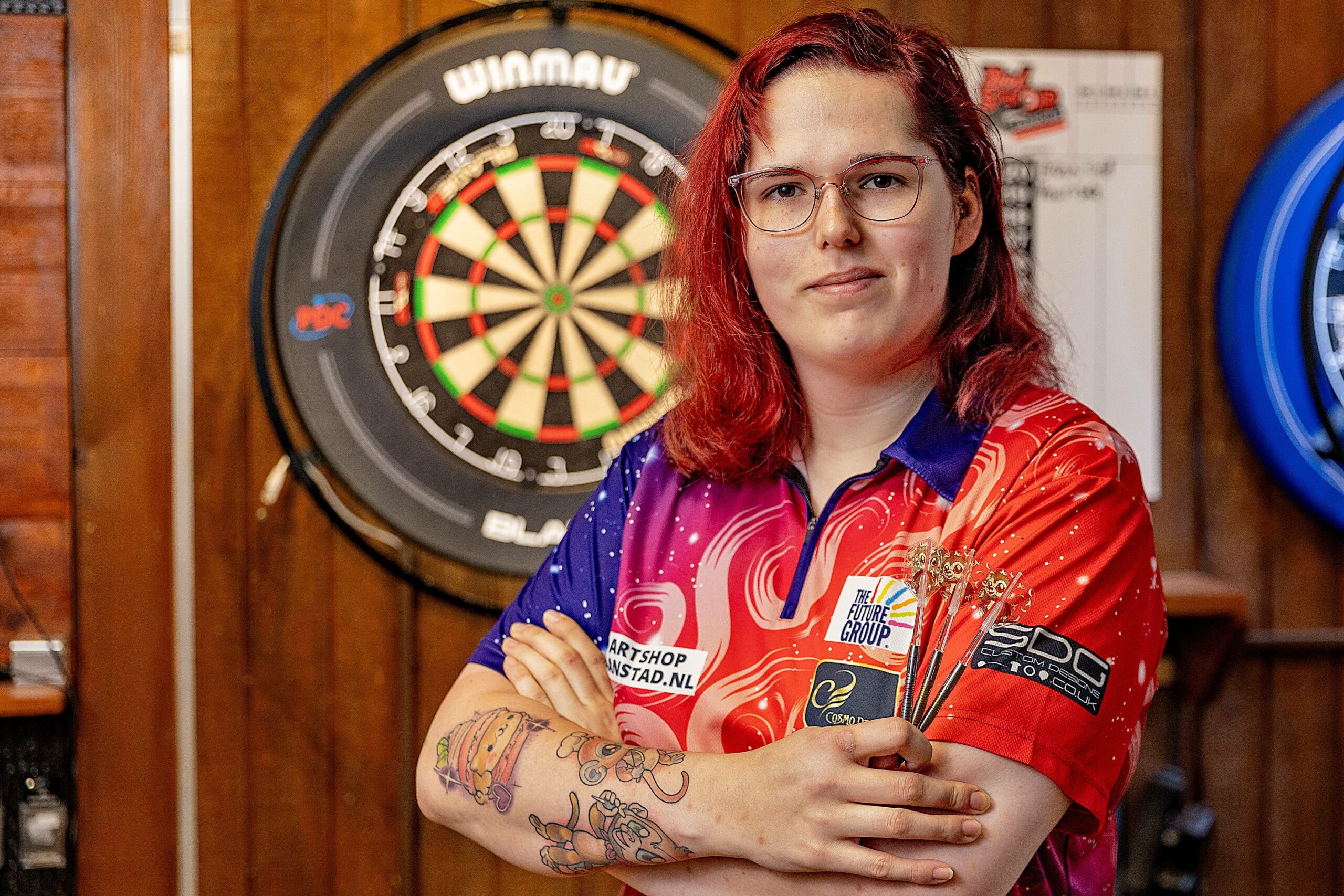 Noa-Lynn van Leuven posiert vor einer Dartscheibe.