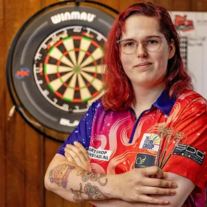 Noa-Lynn van Leuven posiert vor einer Dartscheibe.