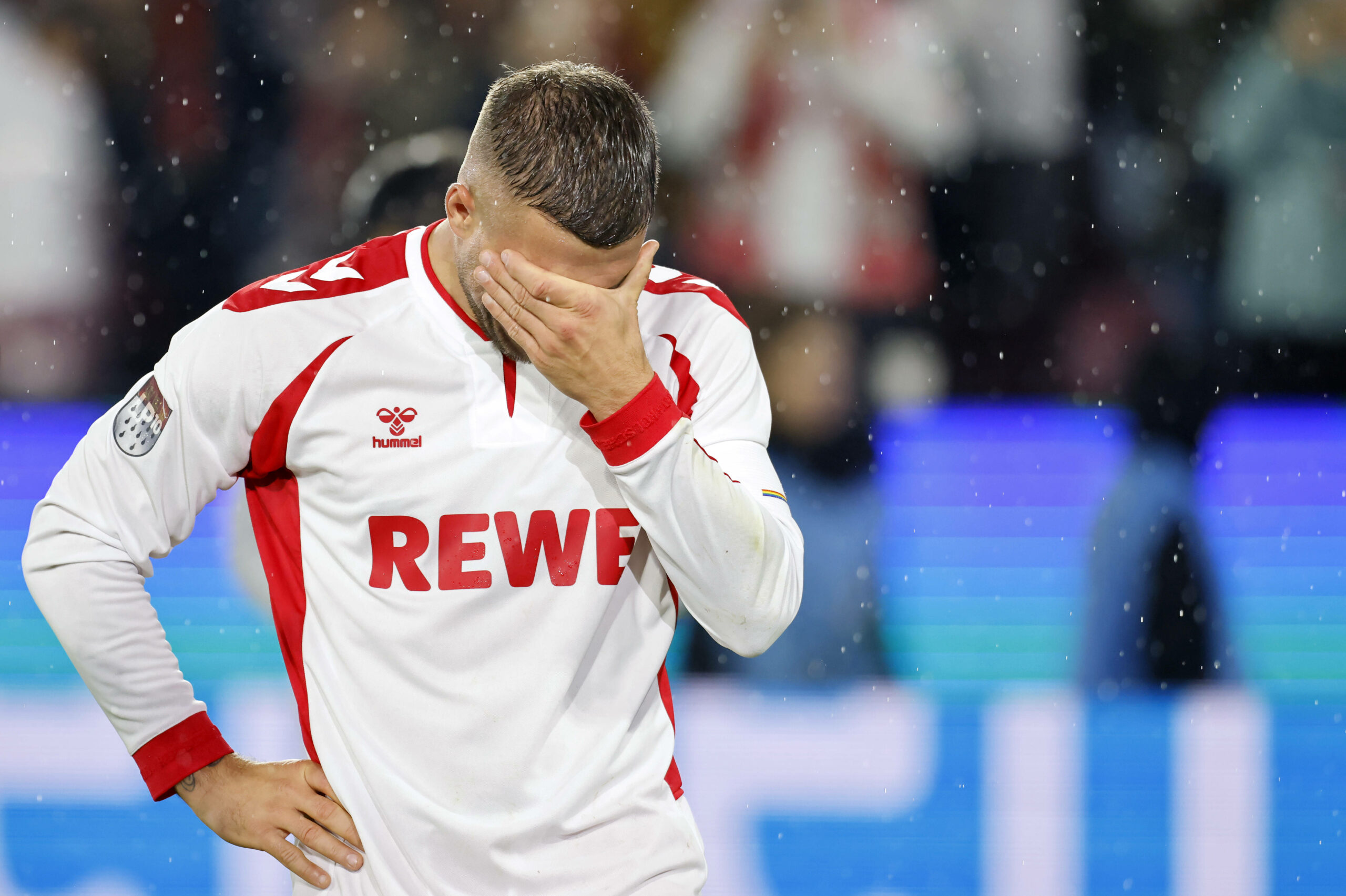 Lukas Podolski hält die Hand vor sein Gesicht