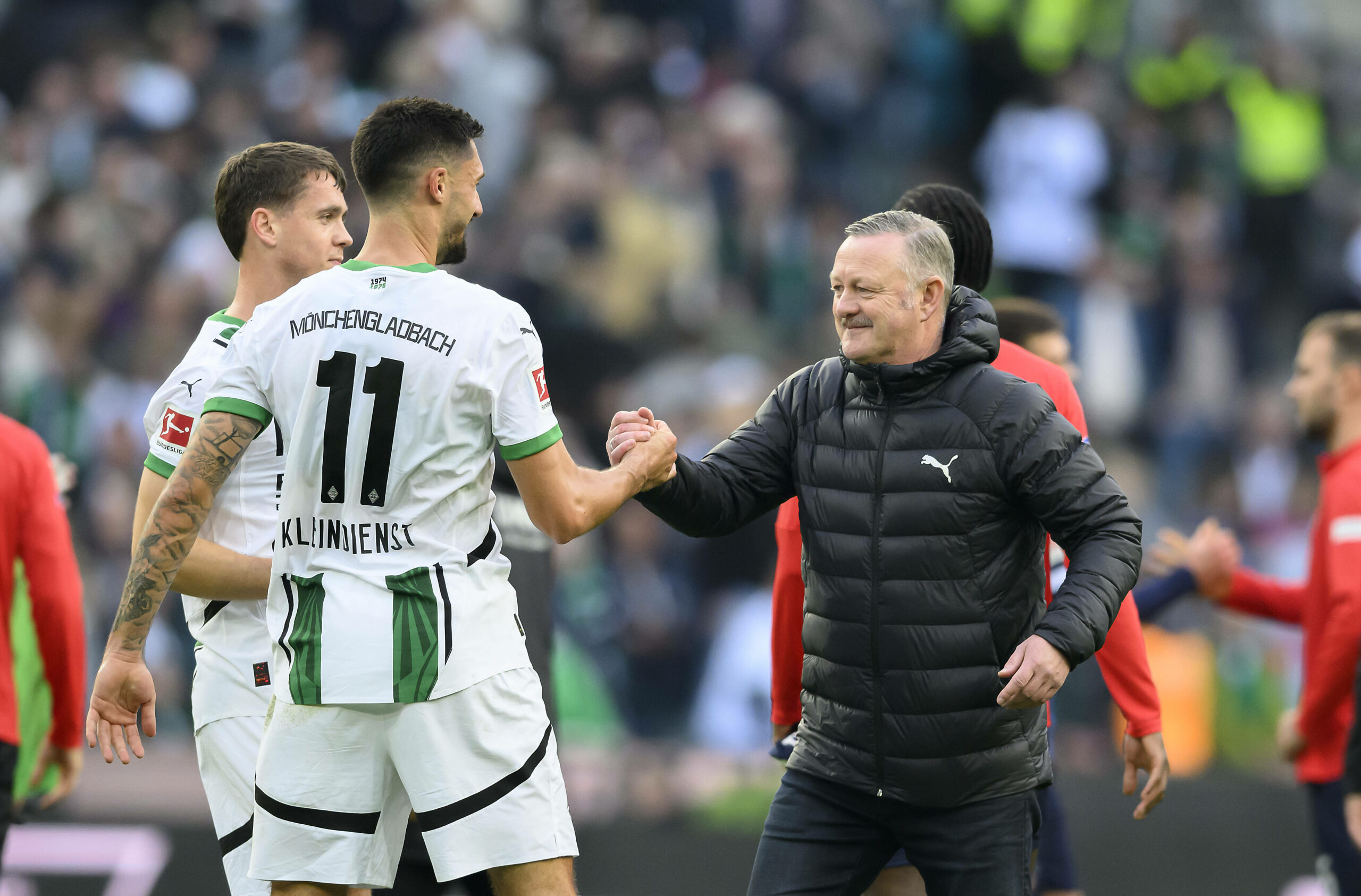 Gladbachs Tim Kleindienst und Geschäftsführer Sport Roland Virkus geben sich einen Handschlag