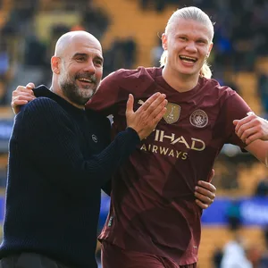 Pep Guardiola und Erling Haaland lachen und umarmen sich