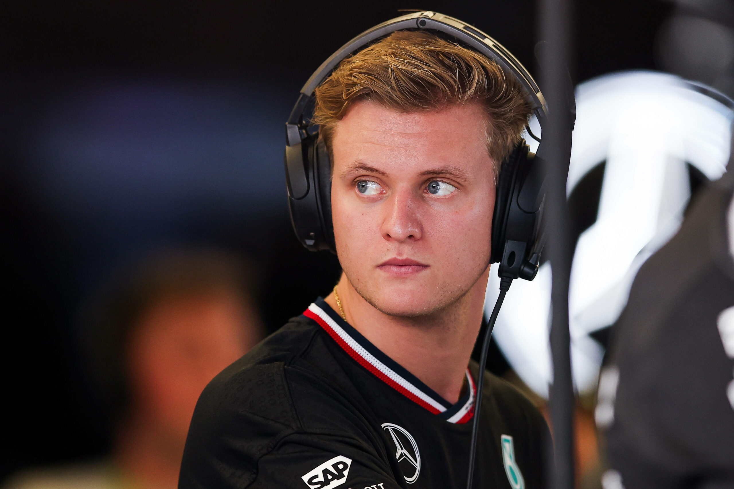 Mick Schumacher in der Mercedes-Box mit Kopfhörern auf den Ohren.