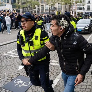 Zwei Polizisten nehmen in Amsterdam einen Mann fest