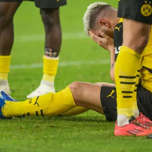 Niklas Süle liegt auf dem Platz und hält sich die Hände vor das Gesicht.
