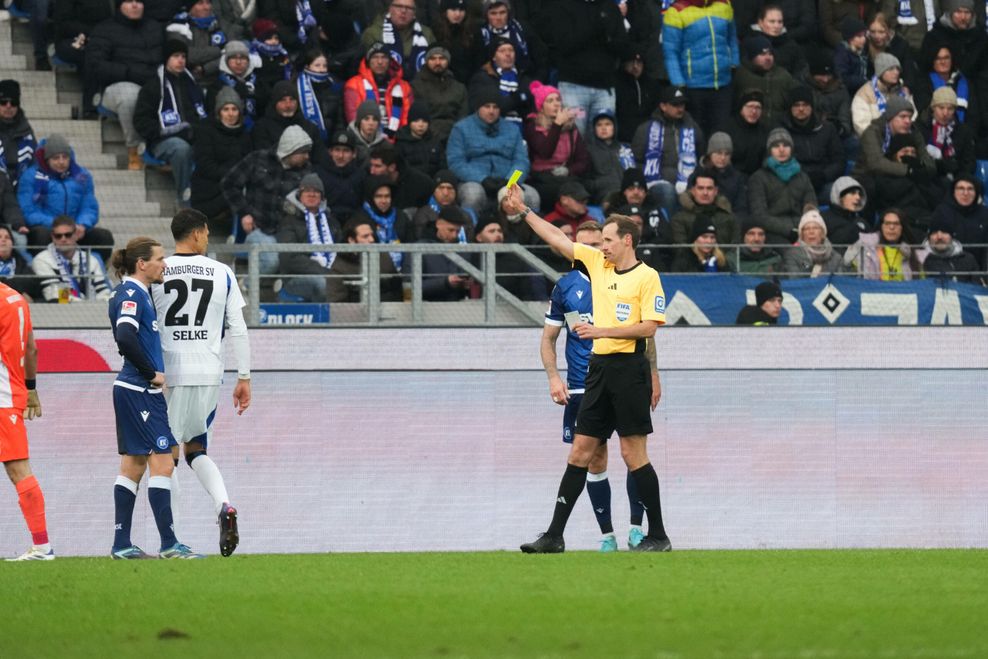 Schiedsrichter Sascha Stegemann zeigt HSV-Stürmer Davie Selke die Gelbe Karte.