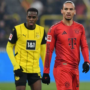 Leroy Sané trabt über den Rasen des Signal Iduna Parks. Neben ihm geht Dortmunds Jamie Gittens.