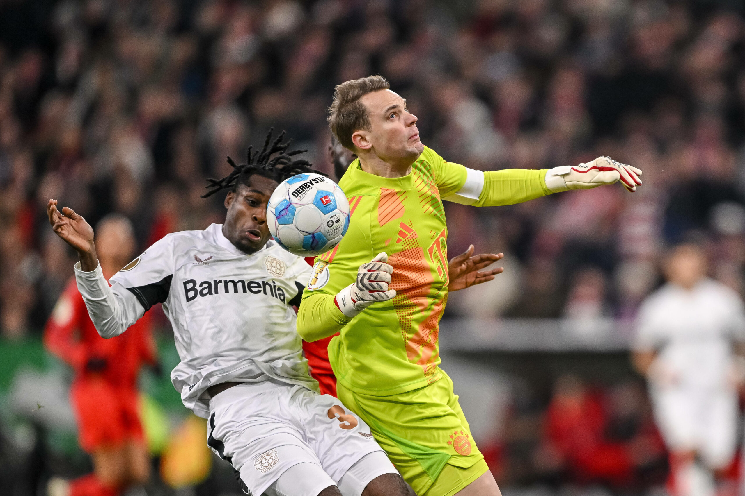 Manuel Neuer steigt rotwürdig gegen Jeremie Frimpong ein.