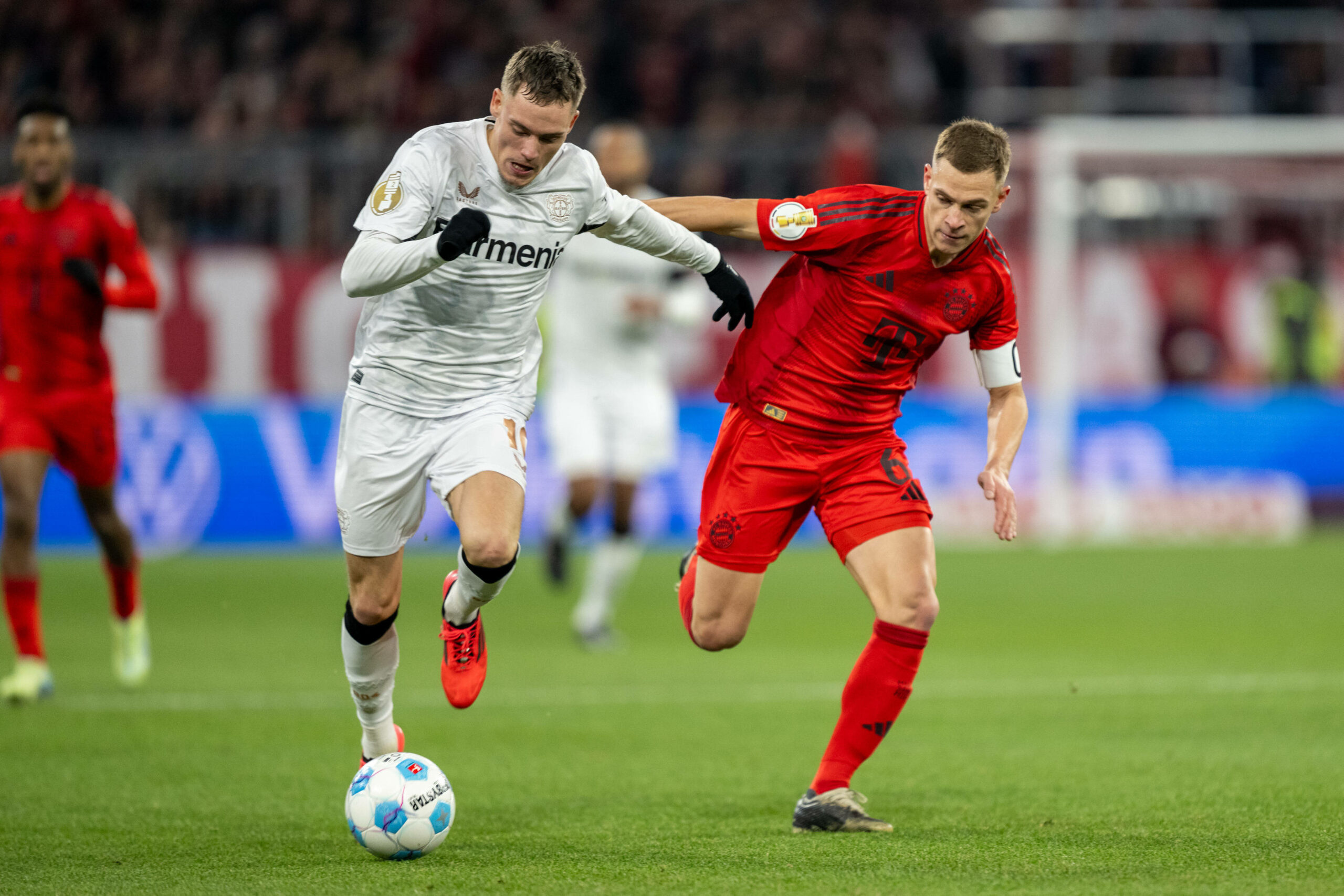 Florian Wirtz mit Ball am Fuß im Laufduell gegen Joshua Kimmich