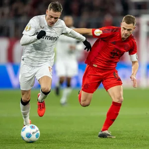 Florian Wirtz mit Ball am Fuß im Laufduell gegen Joshua Kimmich