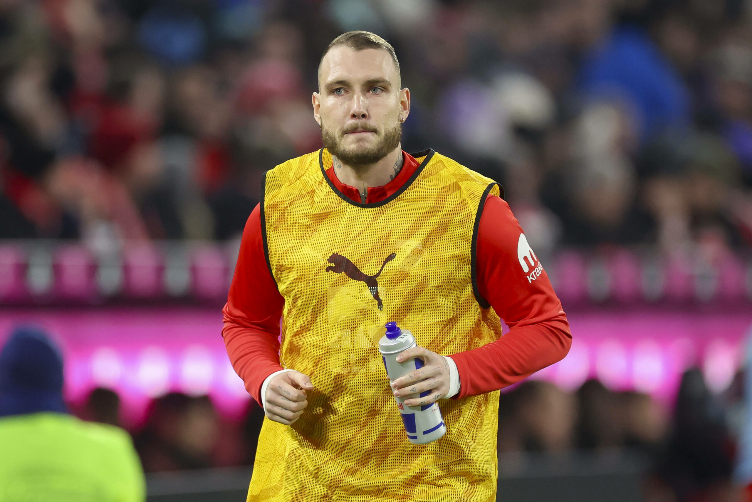 David Raum läuft und hält seine Trinkflasche in der Hand.