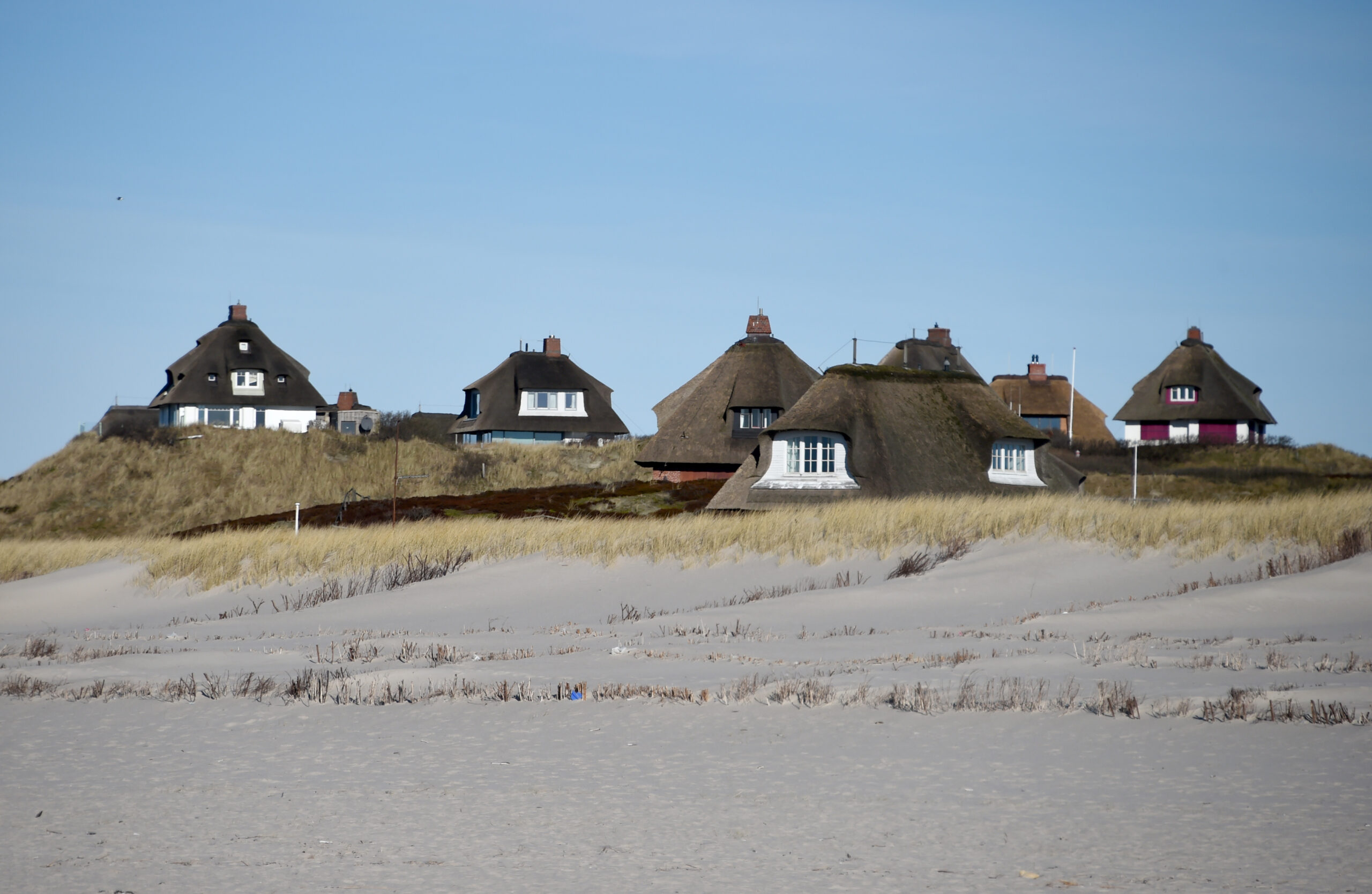 Typische Sylter Reetdachhäuser hinter dem Strand von Hörnum.