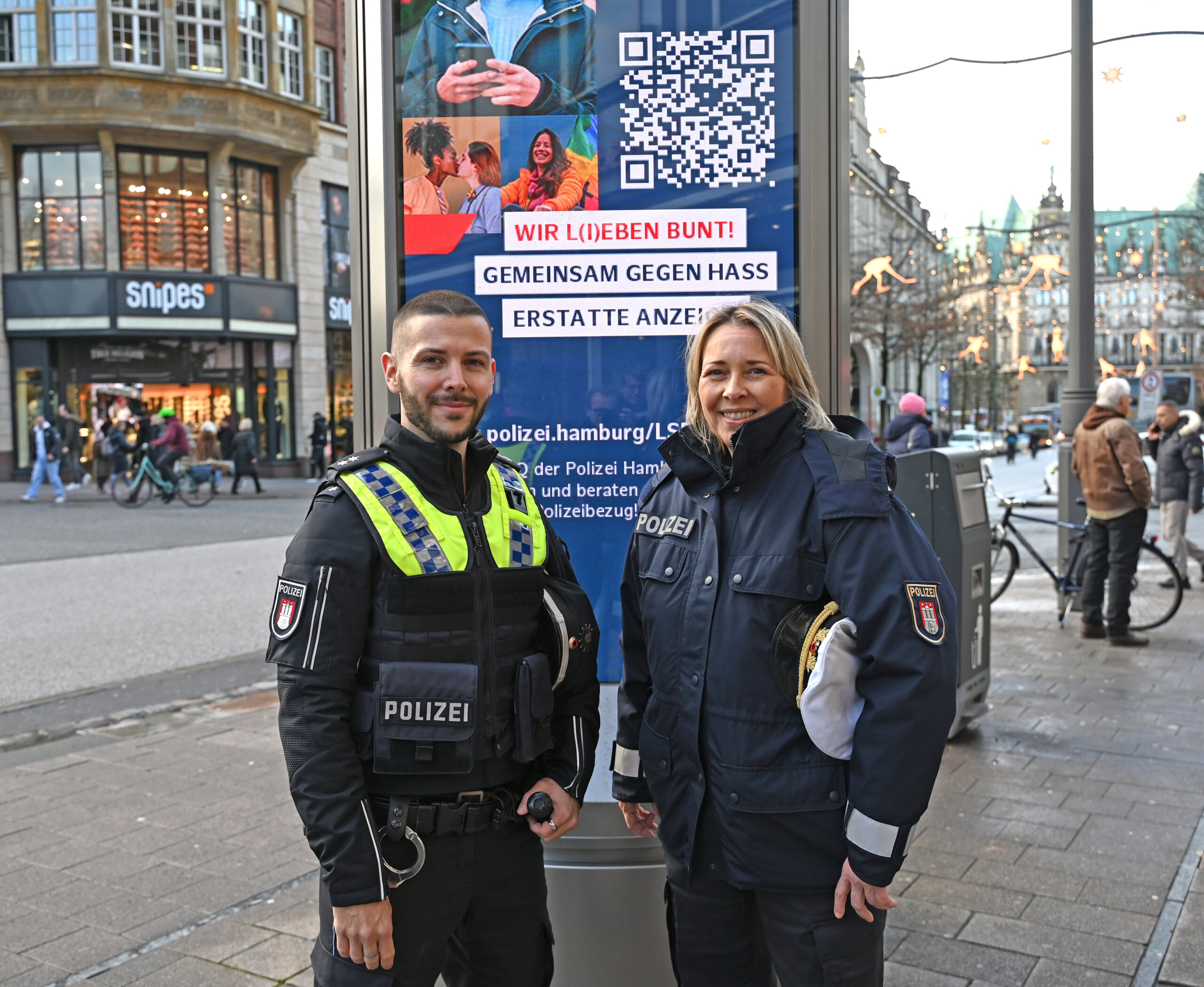 Zwei Polizisten vor Plakat