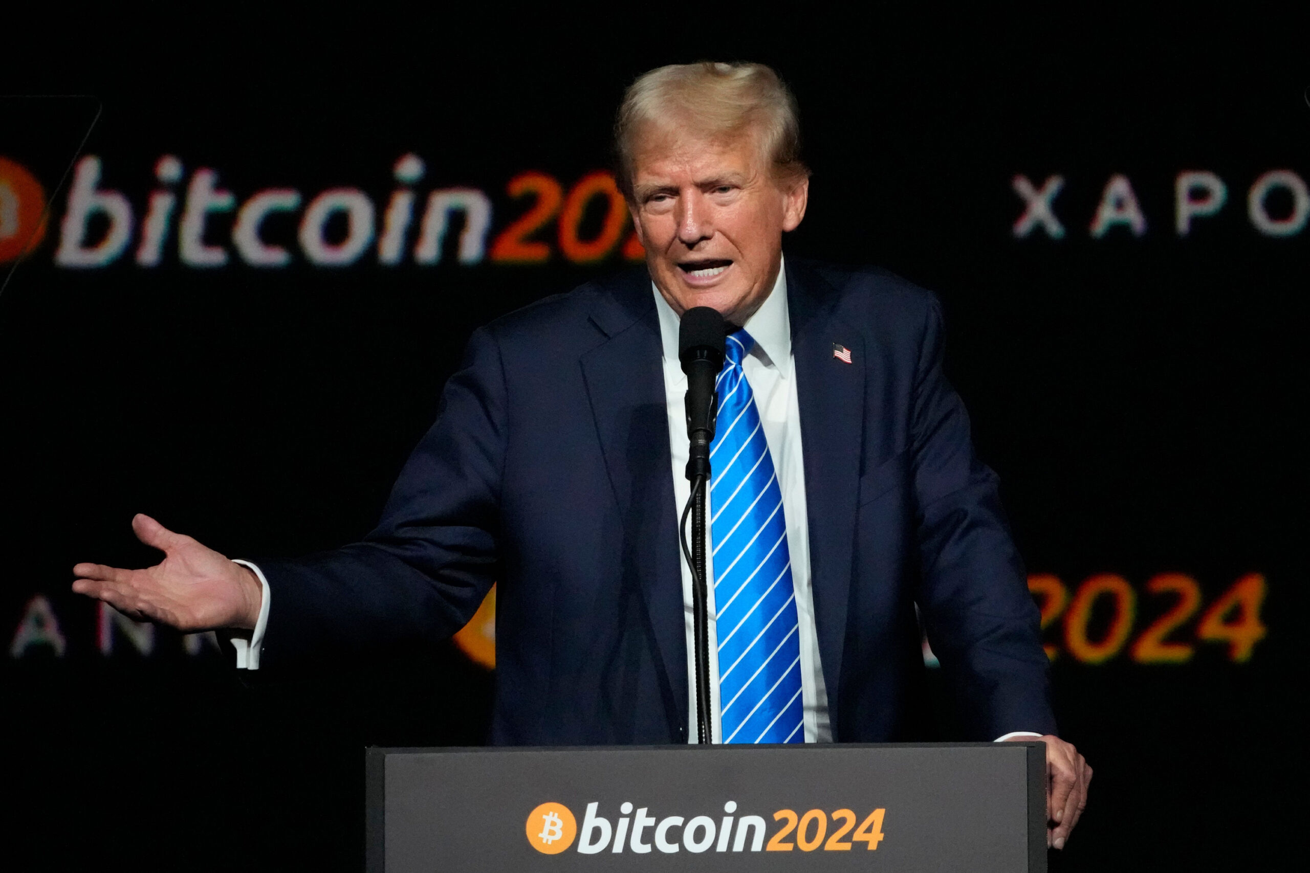 Trump hält Rede auf einem Podest mit Aufschrift „Bitcoin2024“