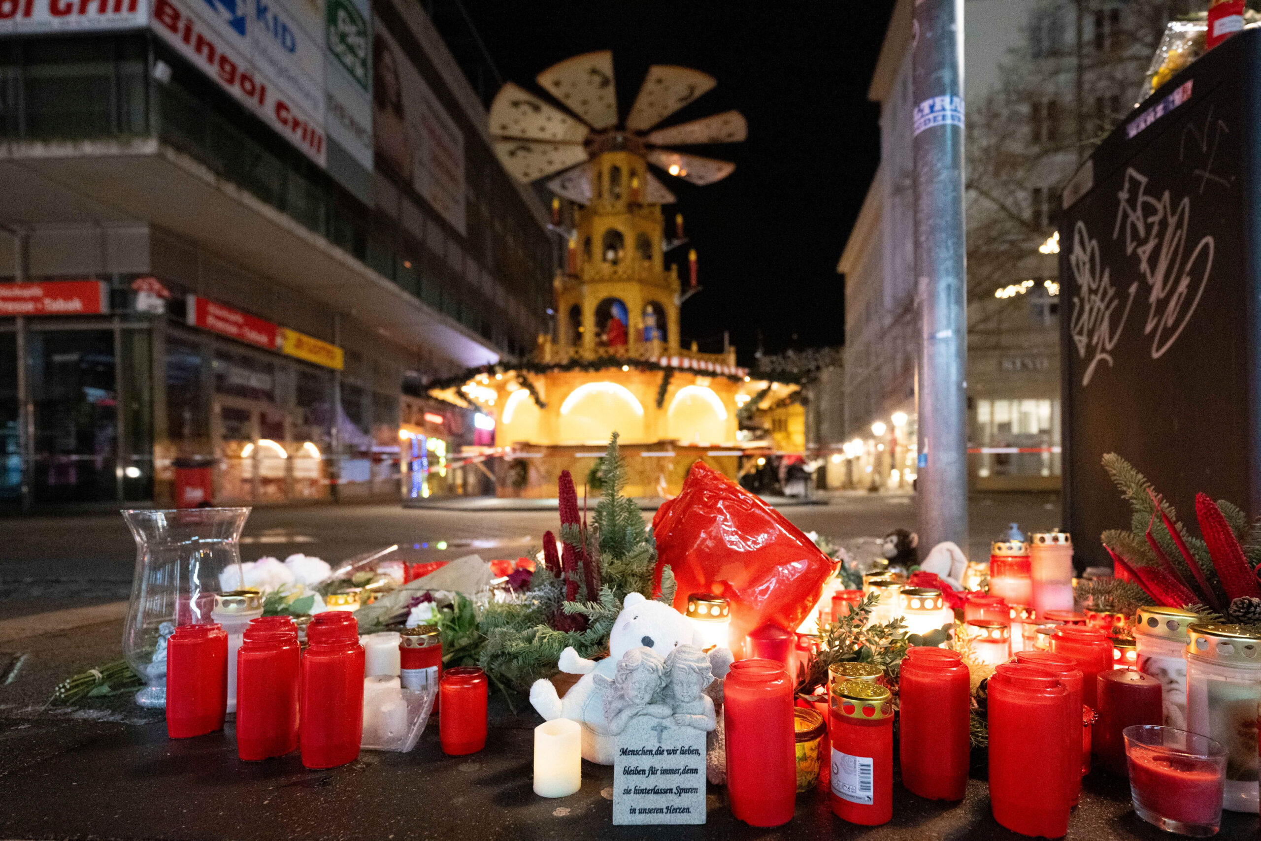 Kerzen und Gestecke liegen am Tatort in Magdeburg.