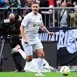 Max Kruse läuft mit einem Lächeln über den Platz