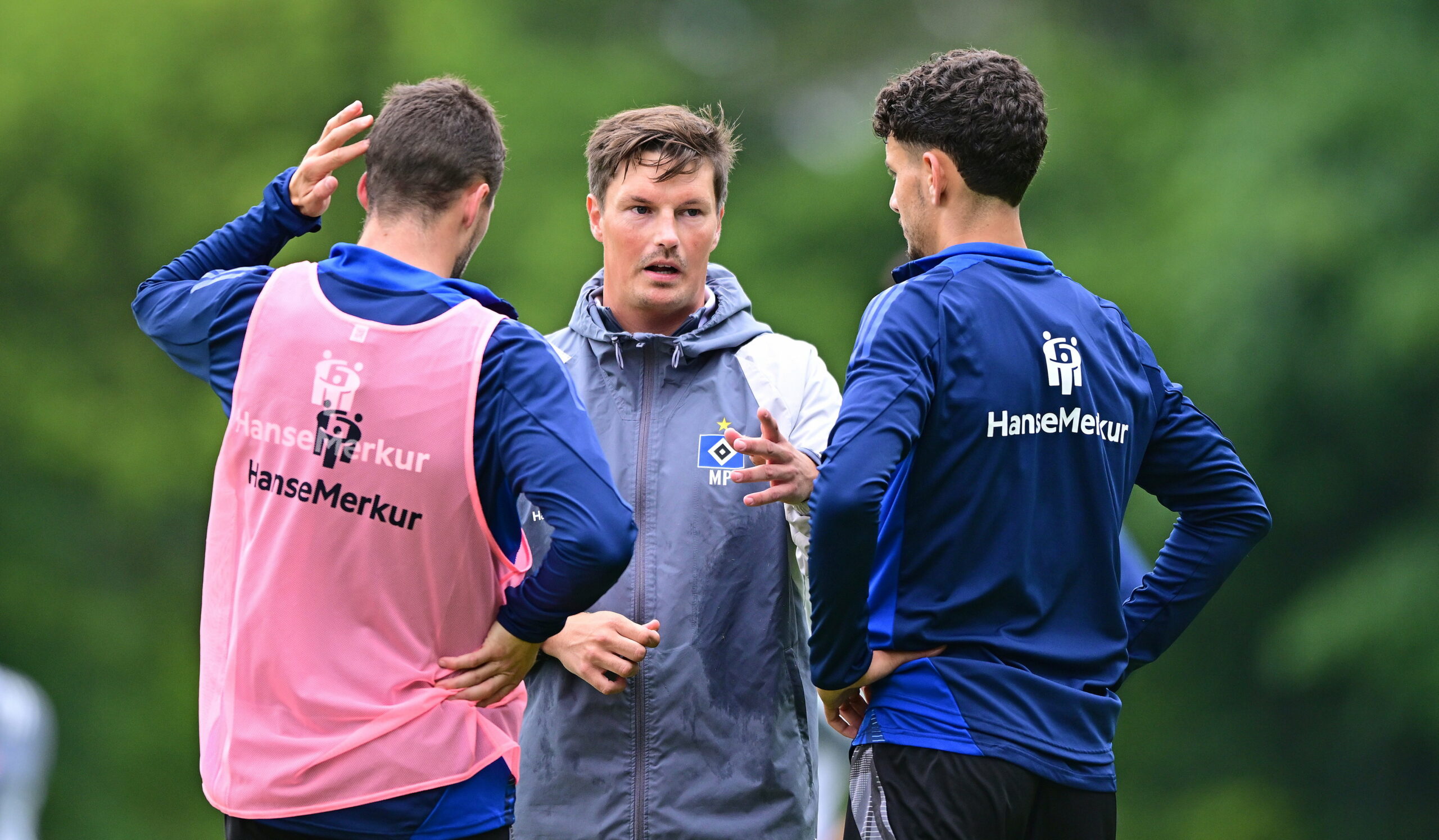 Trainer Merlin Polzin unterhält sich auf dem Trainingsplatz mit Jonas Meffert und Daniel Elfadli.