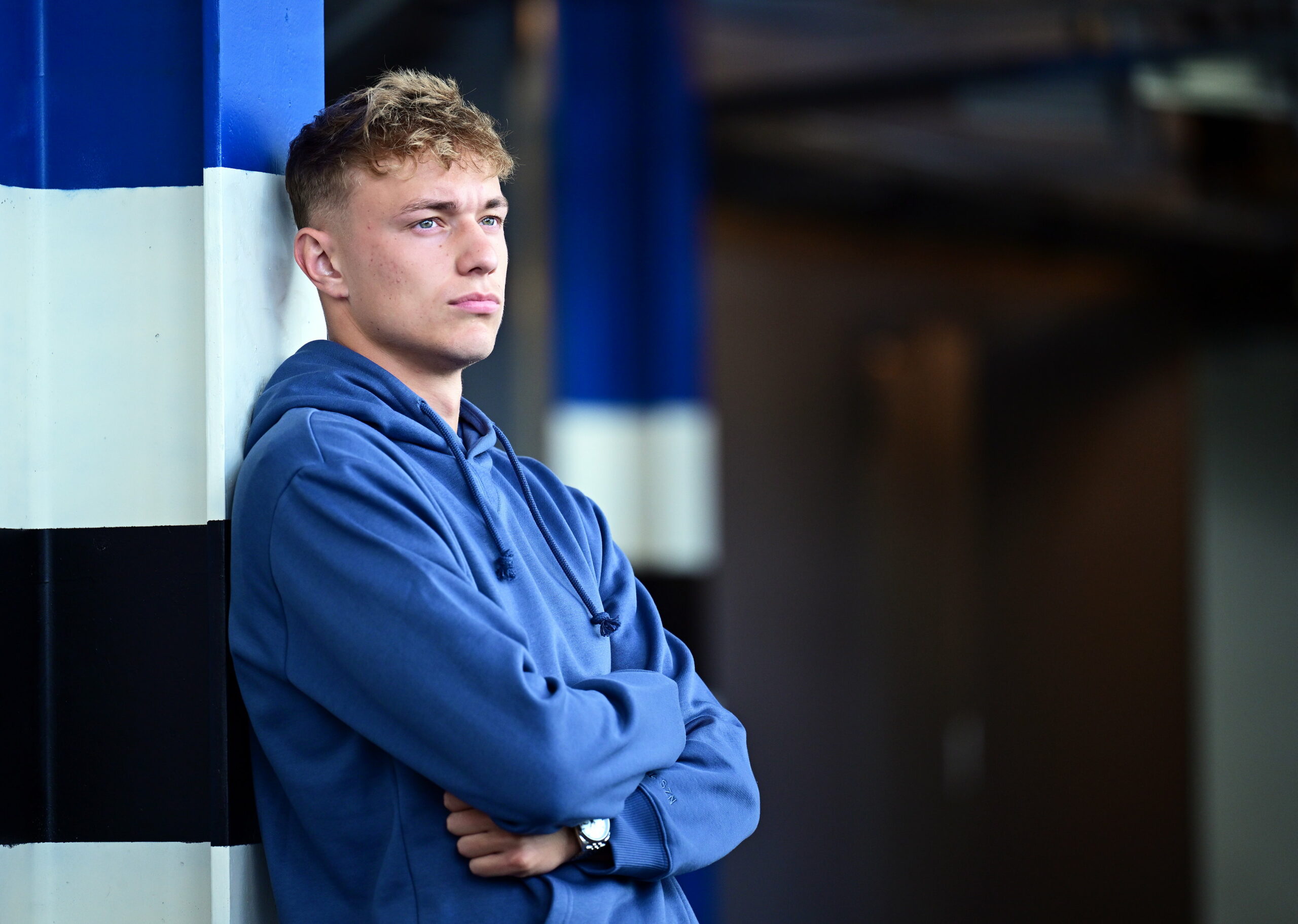 Adam Karabec schaut mit verschränkten Armen durchs HSV-Stadion