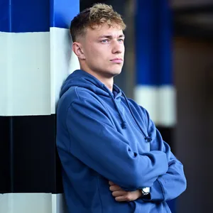 Adam Karabec schaut mit verschränkten Armen durchs HSV-Stadion