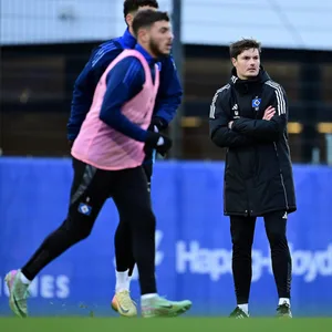 Merlin Polzin beobachten das HSV.Training mit verschränkten Armen.
