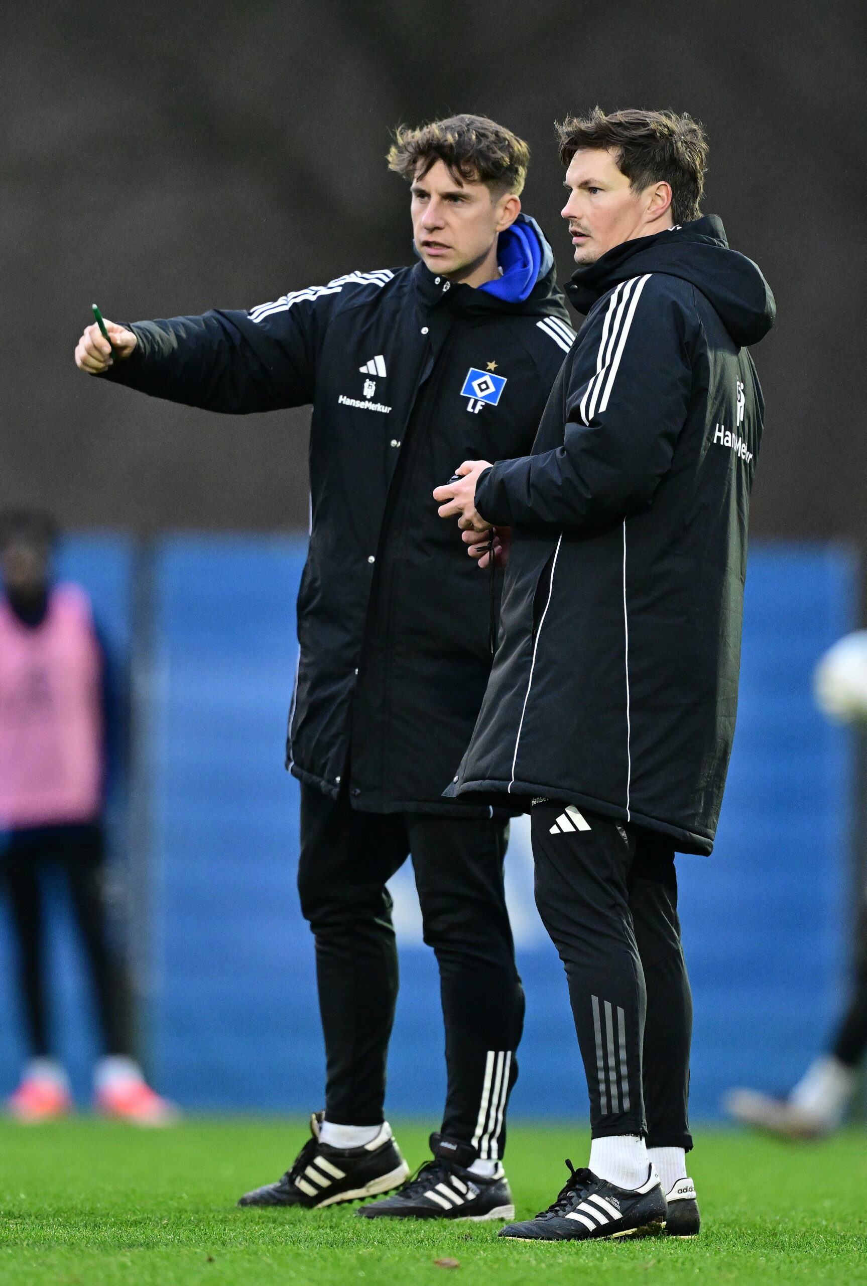 Loic Favé zeigt Merlin Polzin etwas im Training, zeigt in eine Richtung.