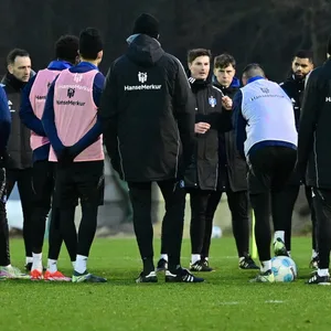 HSV-Trainer Merlin Polzin spricht auf dem Trainingsplatz zu seiner Mannschaft.