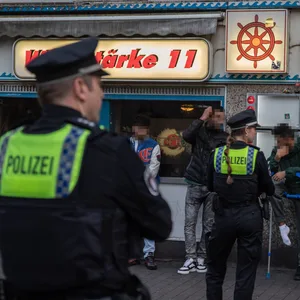 Polizisten stehen bei einer Razzia vor der Kneipe „Windstärke 11“