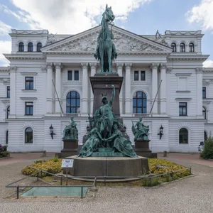 Weißes Haus mit Standbild davor