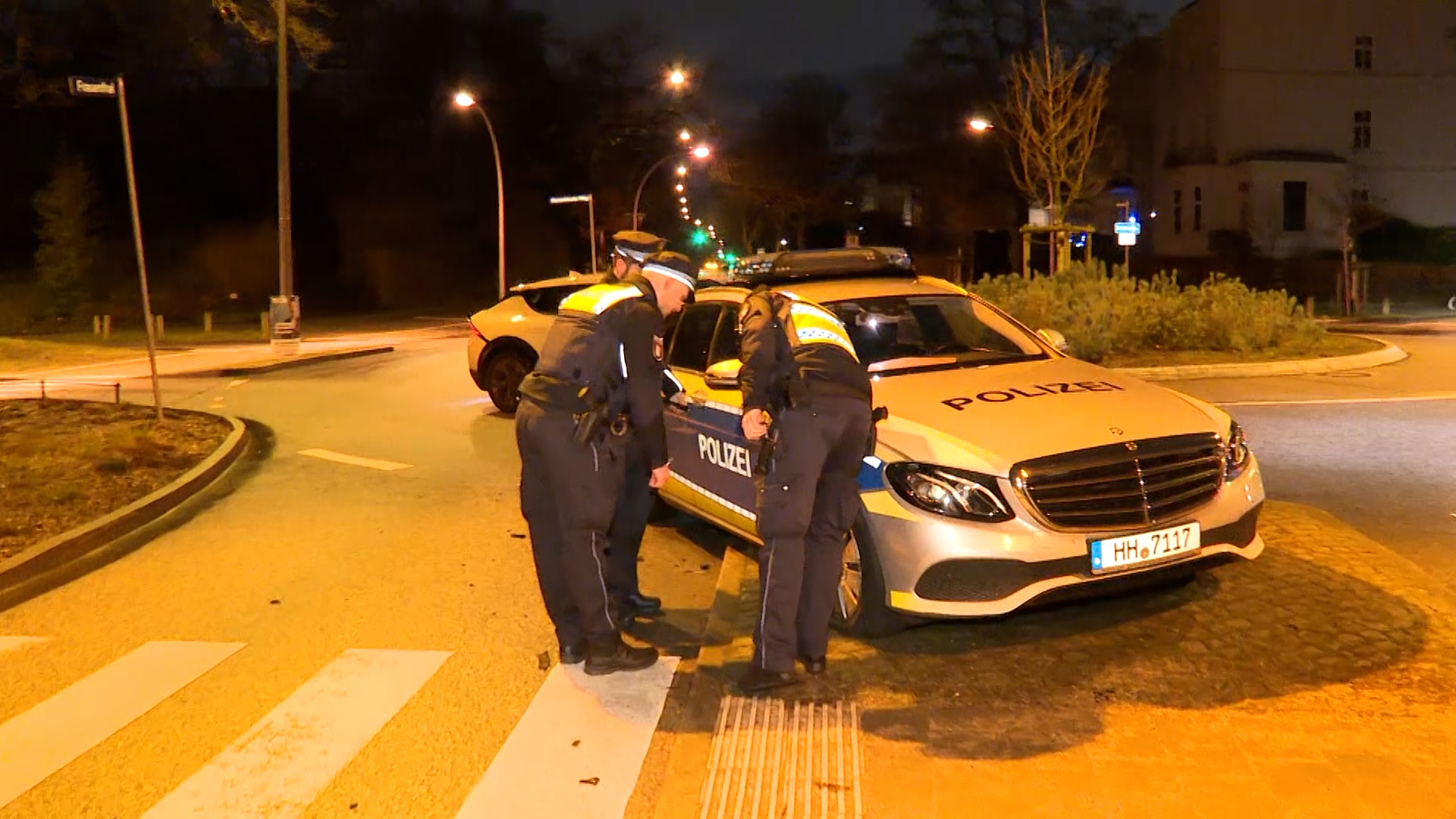 Polizisten begutachten einen beschädigten Streifenwagen