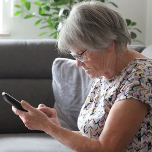 Eine Seniorin mit einem Telefon