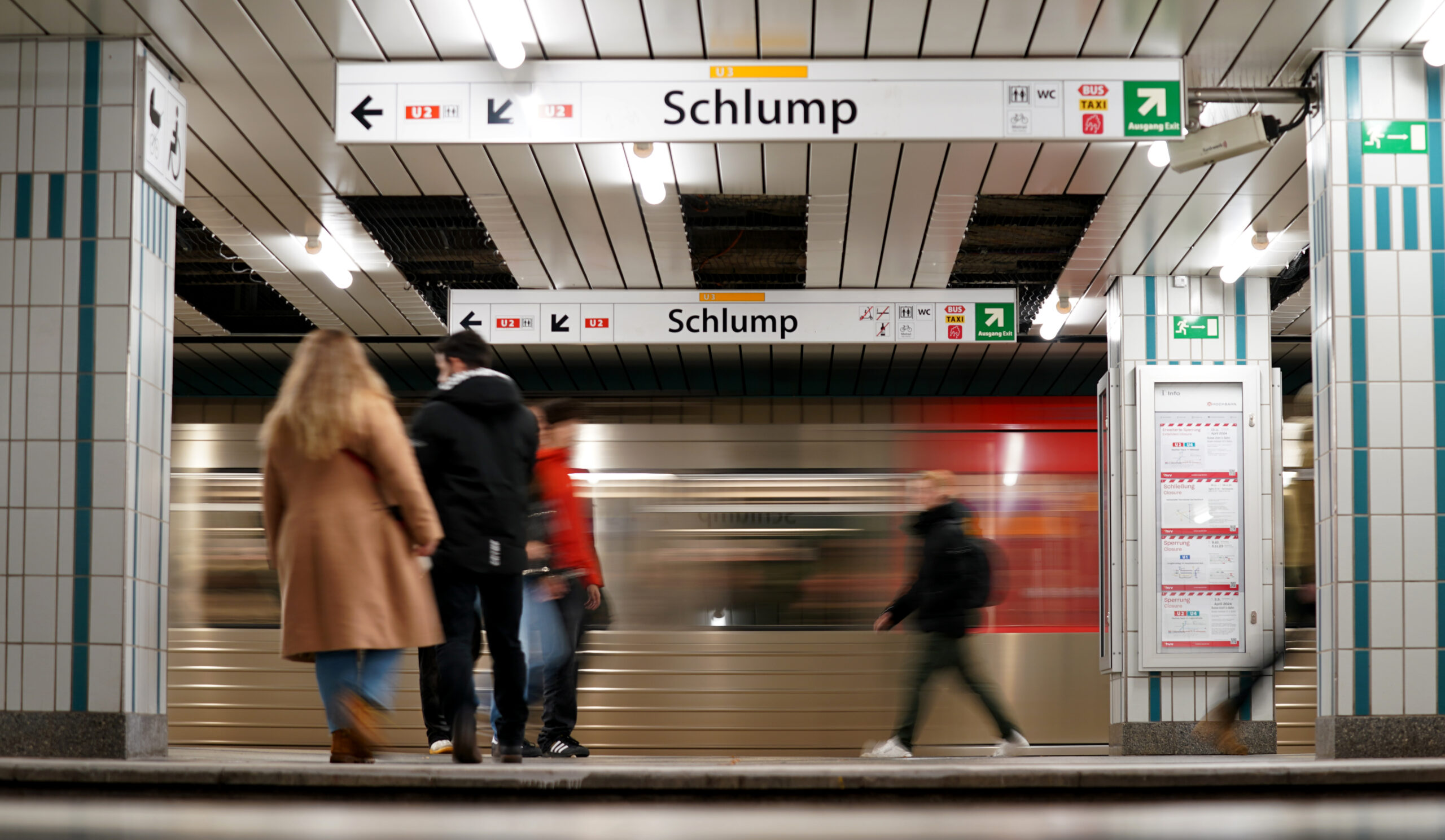 Fahrgäste gehen über einen Bahnsteig im U-Bahnhof Schlump.