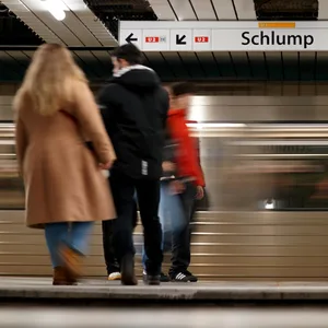 Fahrgäste gehen über einen Bahnsteig im U-Bahnhof Schlump.