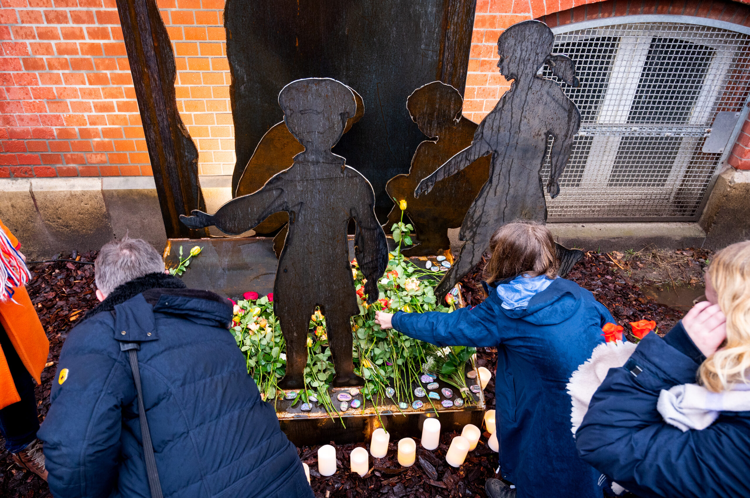 Lehrer und Schüler legen an der Brecht-Schule an einem Mahnmal in Erinnerung an die „Kinder vom Bullenhuser Damm“ Blumen nieder.