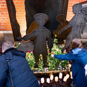 Lehrer und Schüler legen an der Brecht-Schule an einem Mahnmal in Erinnerung an die „Kinder vom Bullenhuser Damm“ Blumen nieder.