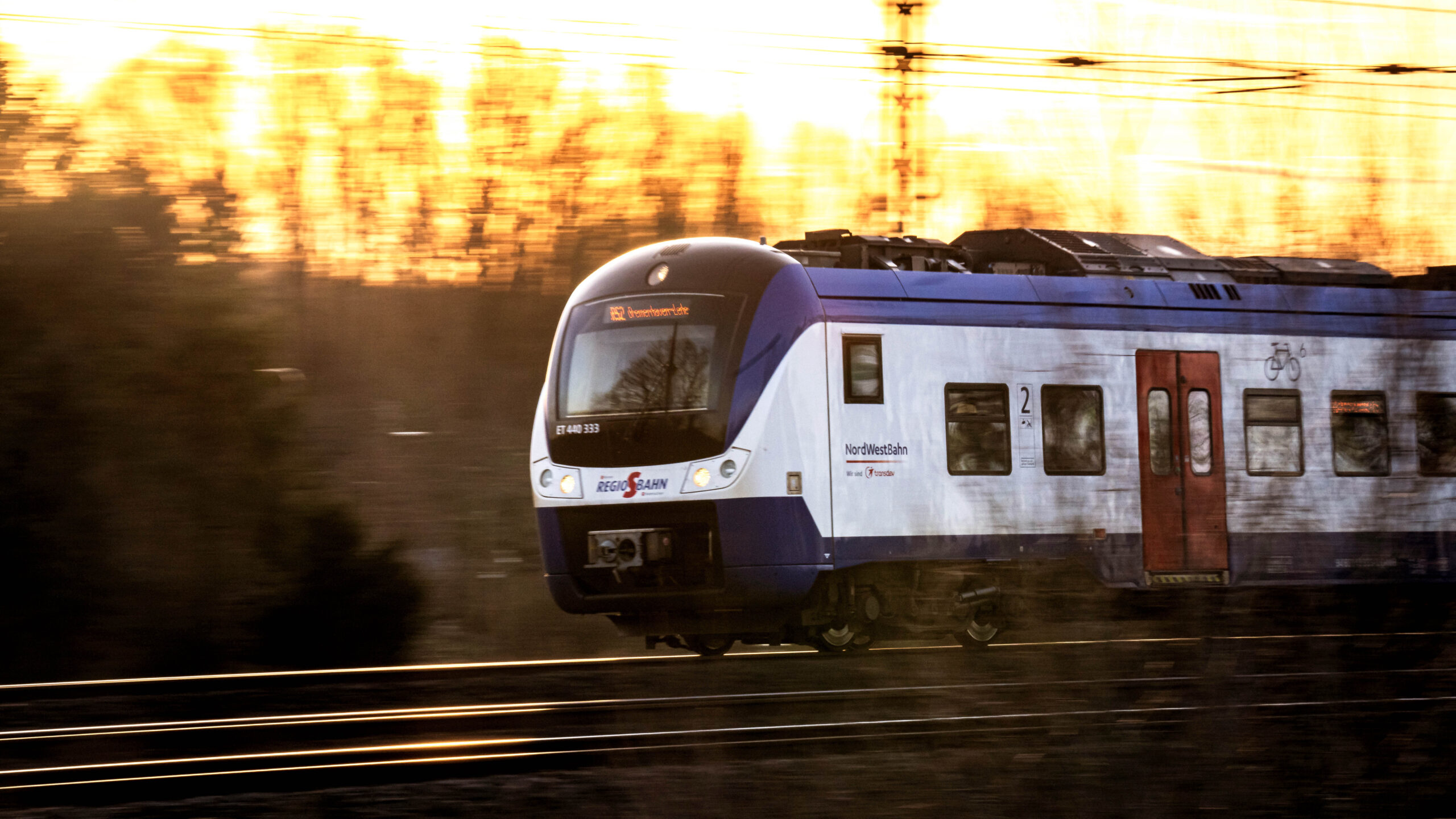 Ein Zug der Nordwestbahn im Sonnenaufgang.