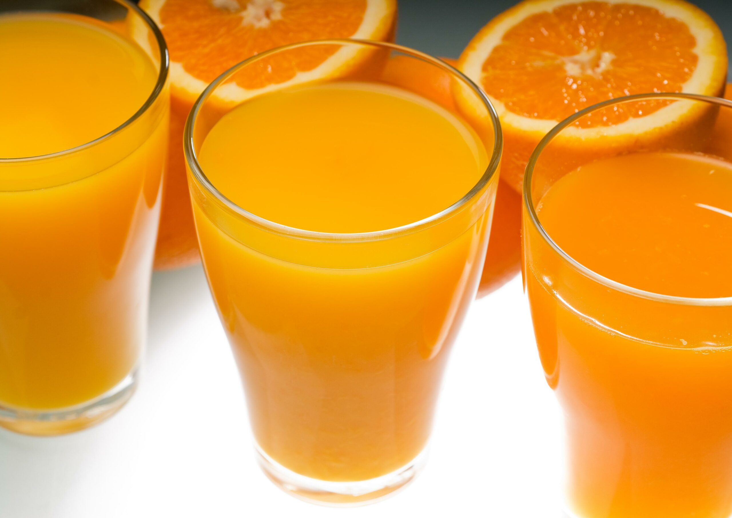 Frischer und gesunder Orangensaft, ungefiltert, auf einem hellen Tisch