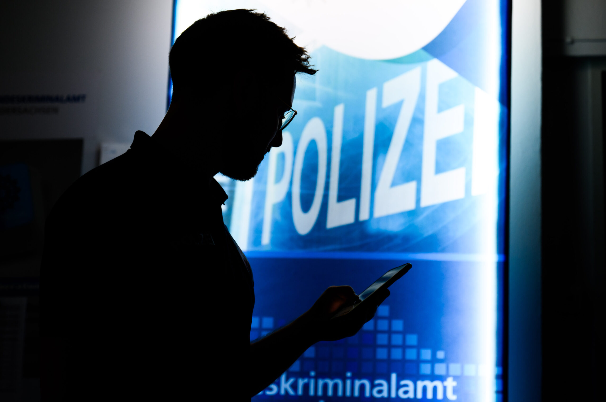 Ein Polizist tippt auf ein Handy