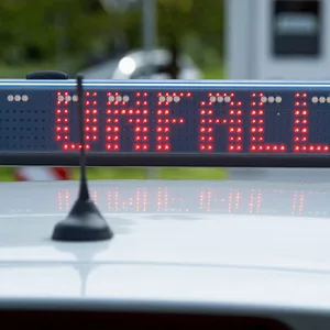 Ein Einsatzfahrzeug, Streifenwagen, der Polizei mit Blaulicht und dem Schriftzug „Unfall“ im Display an einem Unfallort.
