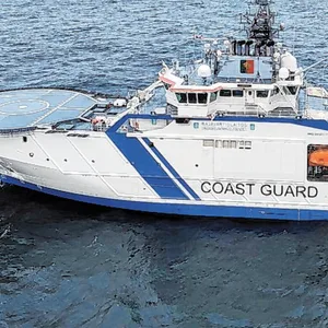 Ein Boot auf dem offenen Meer, im Hintergrund ein Öltanker