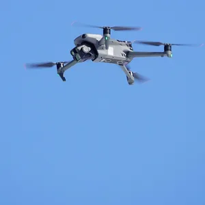 Eine Drohne fliegt im blauen, wolkenlosen Himmel und wird mit einem roten Kreis anvisiert