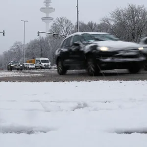 Autos sind nach starkem Schneefall auf einer Hauptverkehrsstraße unterwegs.